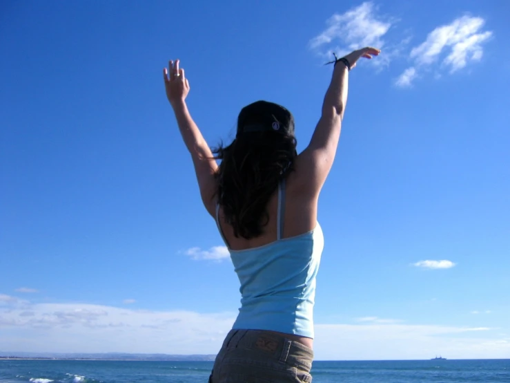 a woman in blue and white dress standing by the ocean