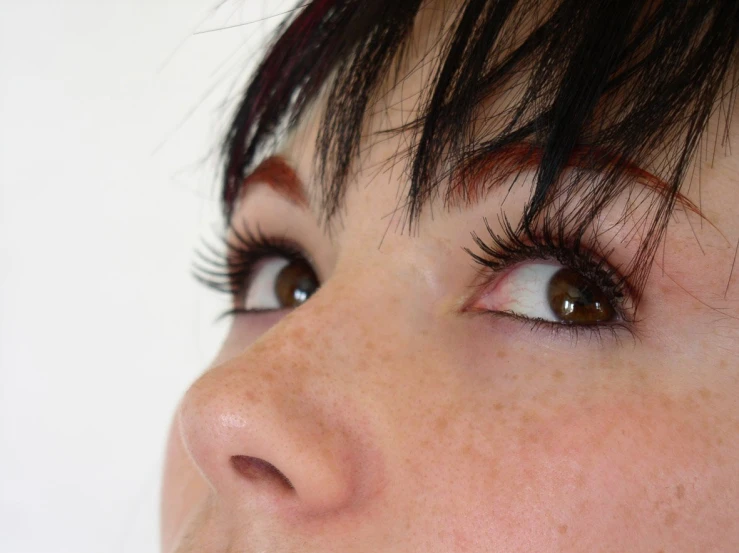 a close up of a woman's face with her eyes open