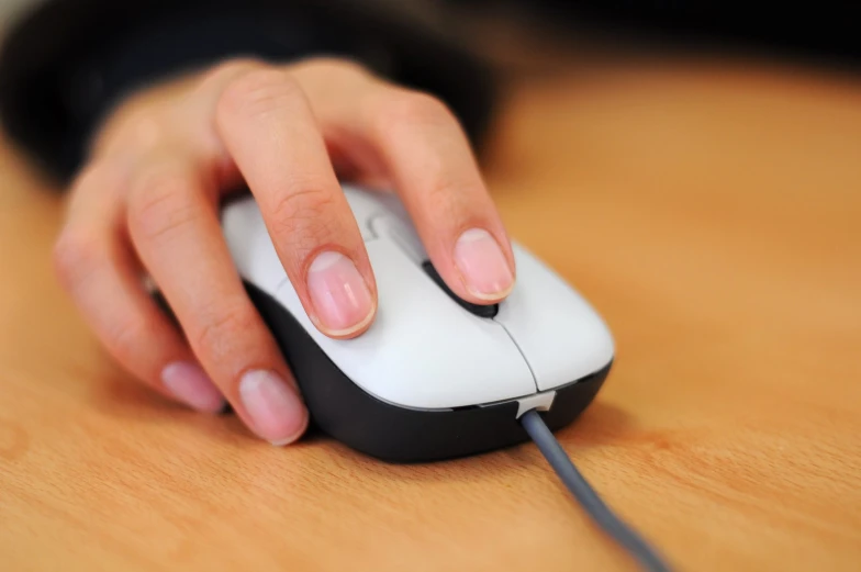 a person's hand on a mouse with the top on slightly down