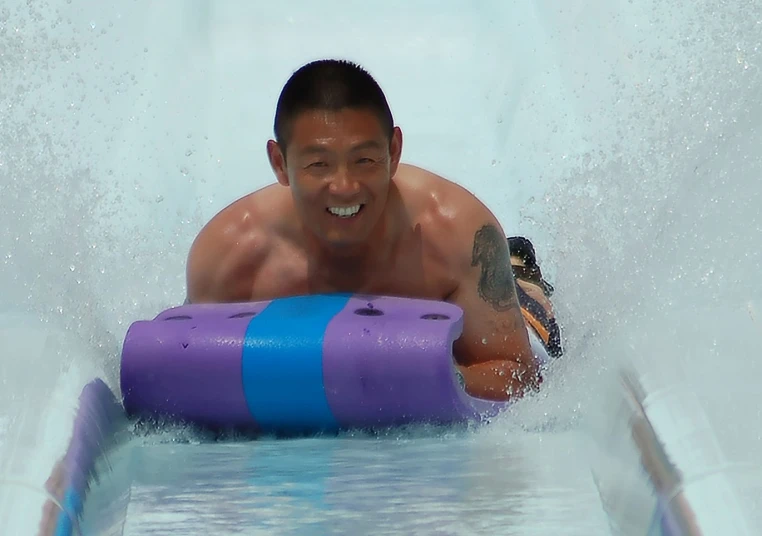 man riding down the inside workings of a wave machine in a water park