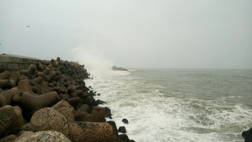 waves crashing onto the beach on a cloudy day