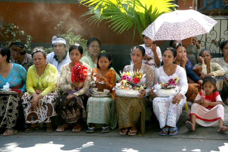 a group of people sitting next to each other in front of a building