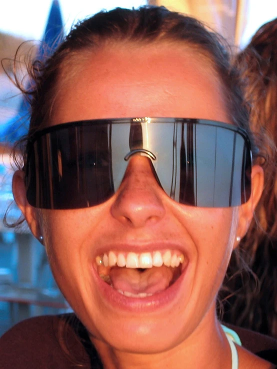 a close up of a woman wearing sunglasses smiling