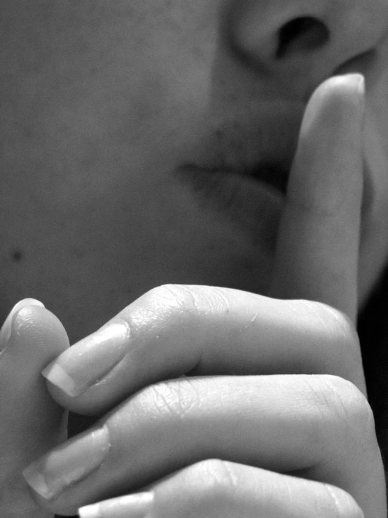 a person's hand on her finger, close to their face