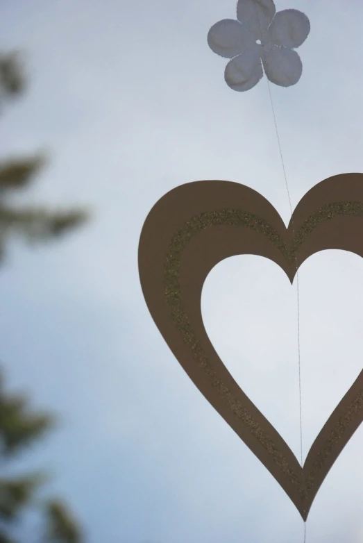 there is a heart shape with two balloons in the air