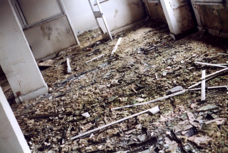 an abandoned kitchen with broken cabinets and a few doors