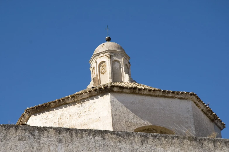 a white steeple with a cross atop it