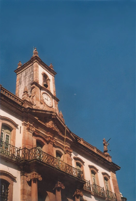 an old building with a clock tower with balcony rails