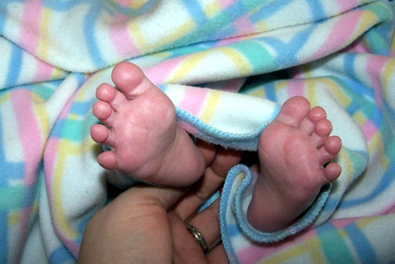 a baby laying down on top of a blanket under a blanket