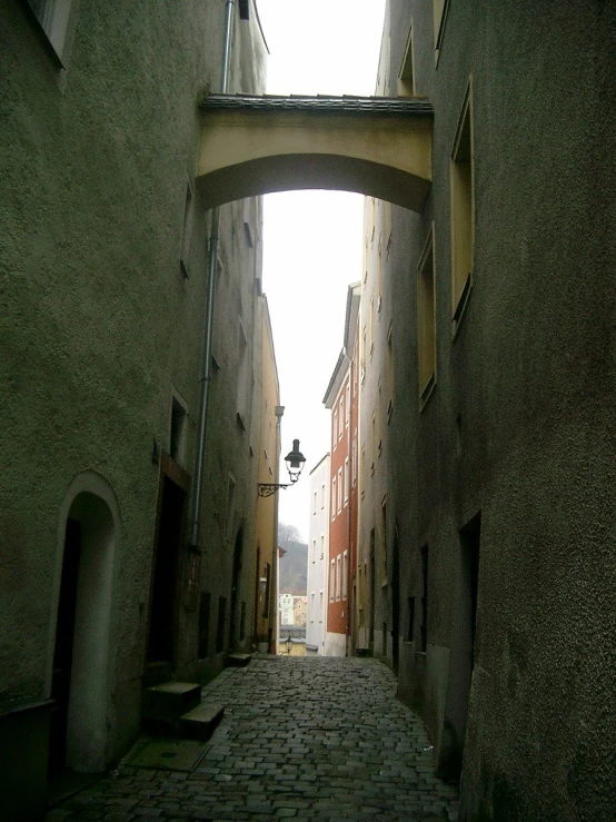 narrow alleyway leading to two buildings with windows above