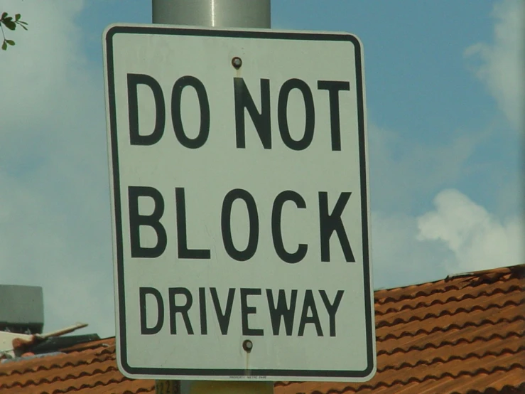a white sign with a do not block on it that says, don't block driveway