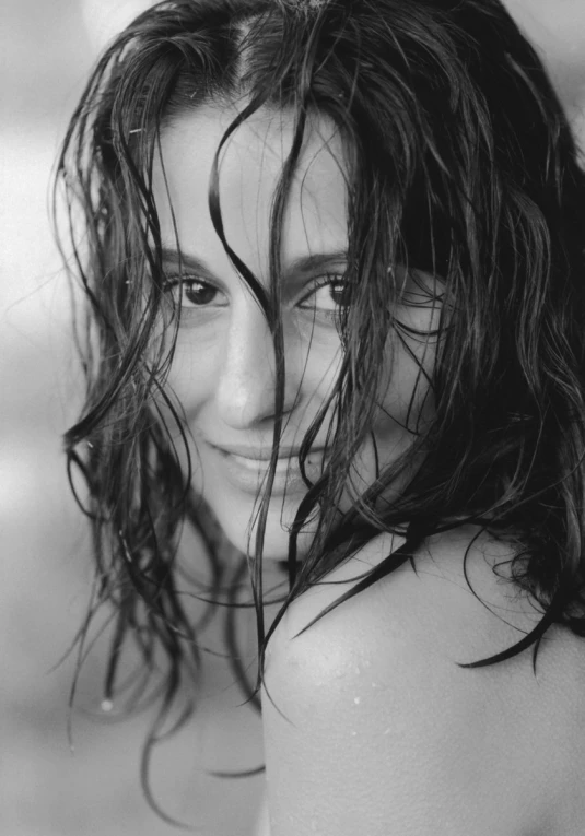 a black and white po of a smiling woman with wet hair