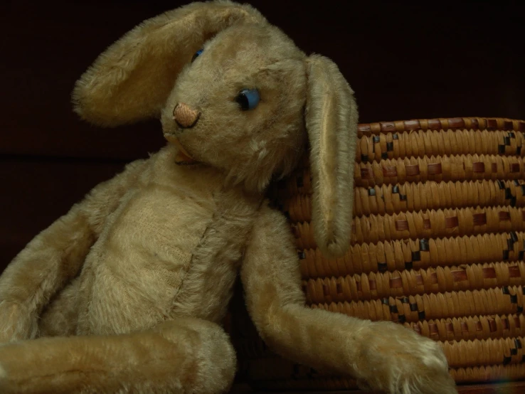 a brown stuffed animal sitting next to a woven basket
