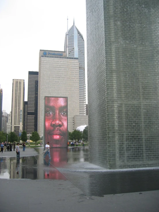 a statue depicting a man with a pink face is behind it in the middle of a large city