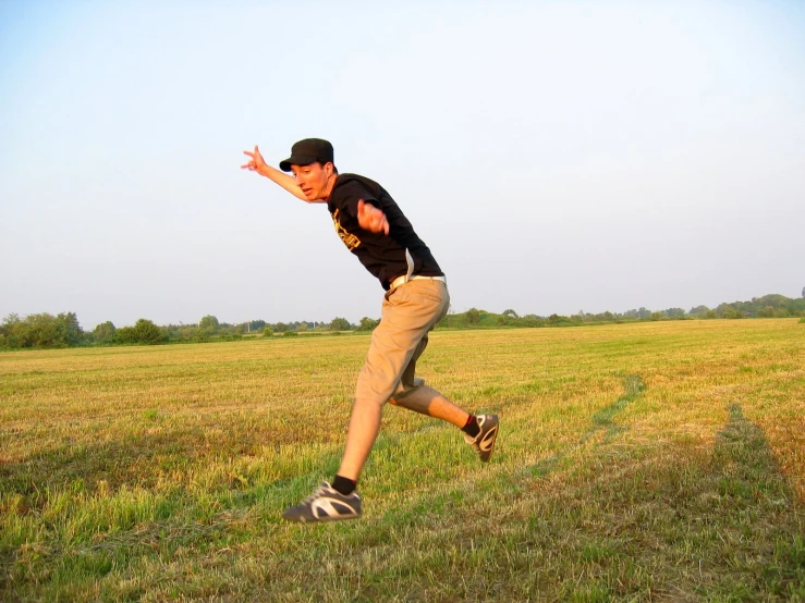 a man running across a grass field next to a field