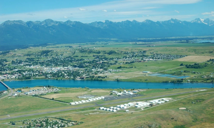 a small town surrounded by the mountains with a lake