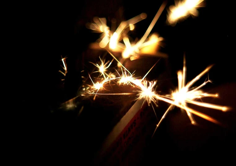 sparklers with lights reflected in them on black background