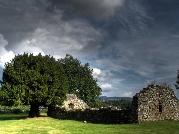 an old ruin with a gate near the trees