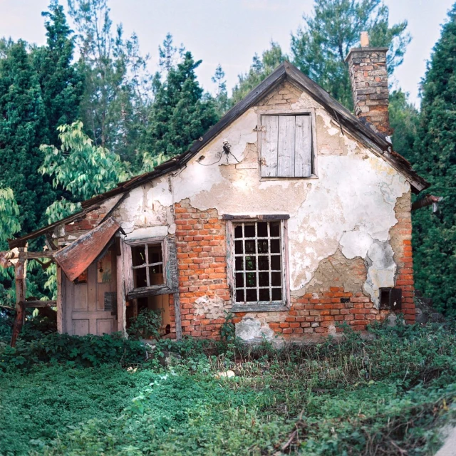 an old abandoned brick house sitting in a garden