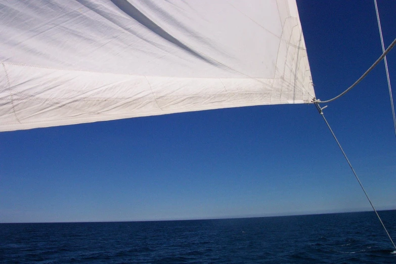 a sail boat sailing in the ocean under a blanket