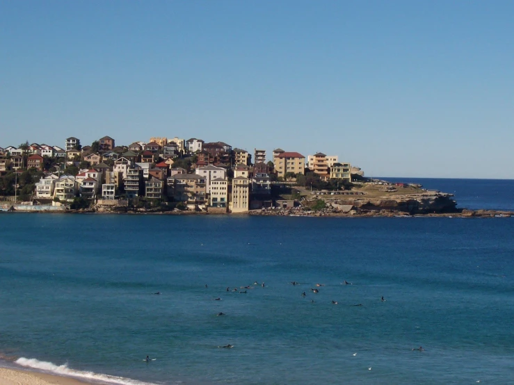 a beach and the city of an island with people standing in it