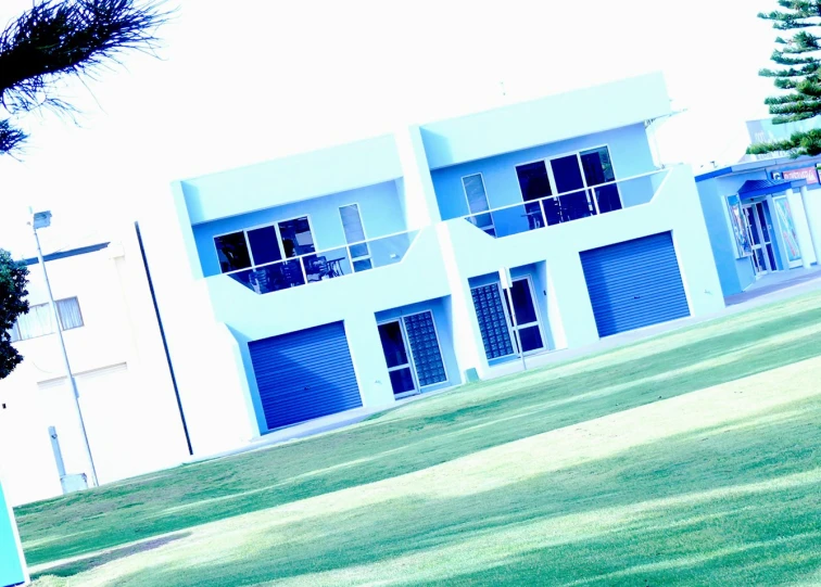 an apartment building with several windows in the grass