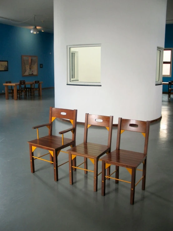 a number of chairs sit in a room