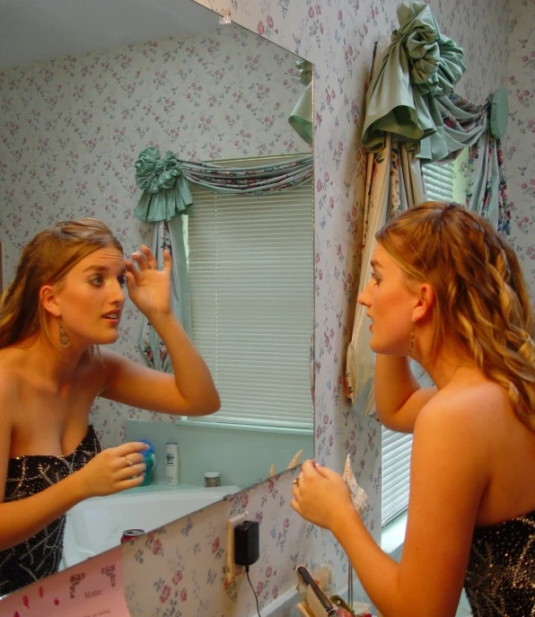 a lady is drying her hair while another lady is brushing