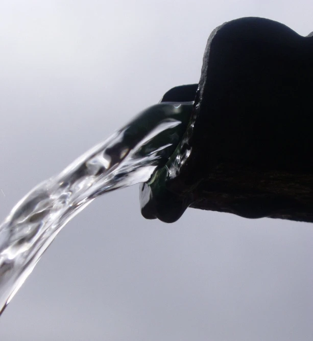 a stream of water running down a metal pipe