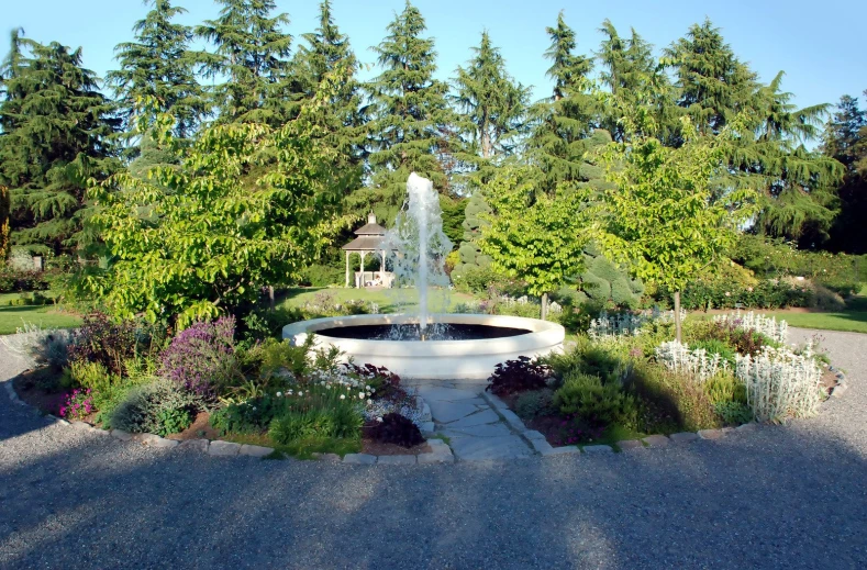 there is a fountain in the center of the garden