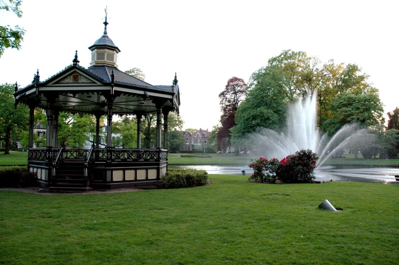 a gazebo with a fountain in the background