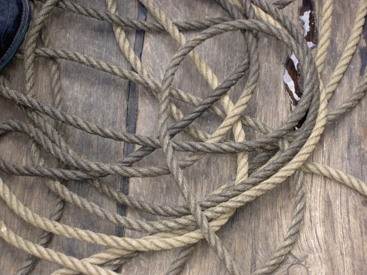 a pair of black shoes and ropes that are sitting on a wooden floor