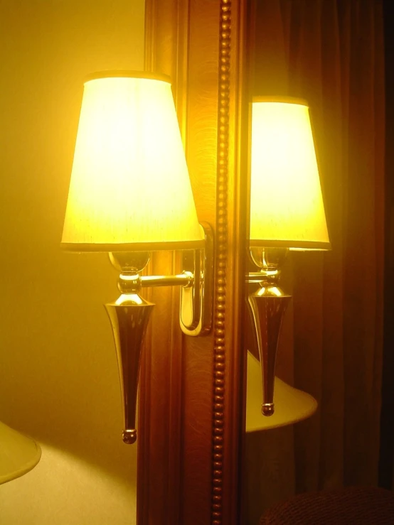 a pair of lamps are seen in the mirror
