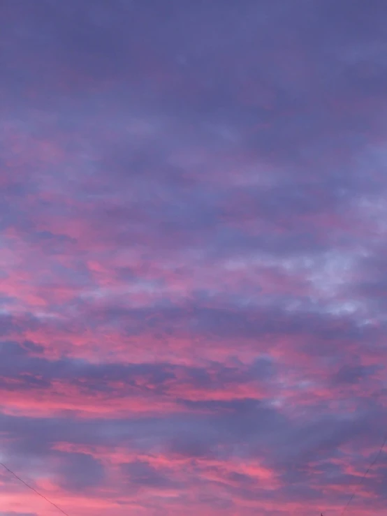 a man flying a kite over a beach during sunset