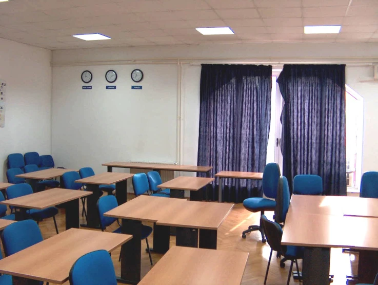 empty desks in a classroom with blue chairs