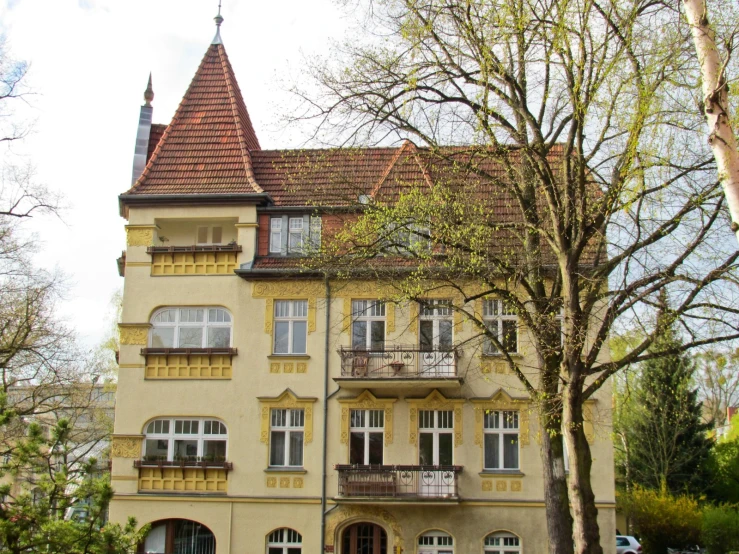 a house with several balconies near the trees