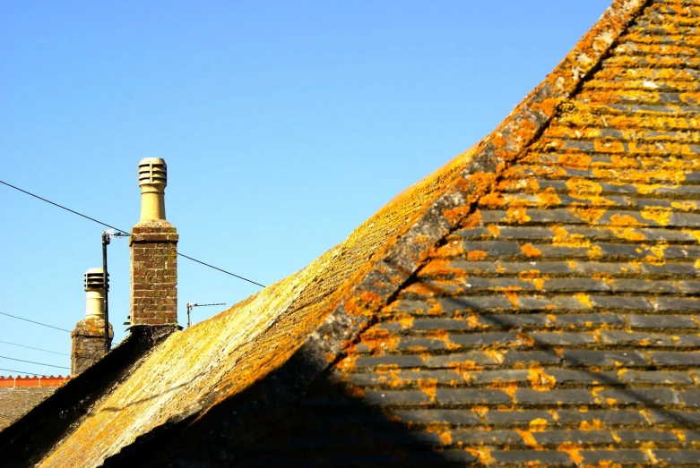 an old chimneys stand next to a building and wire