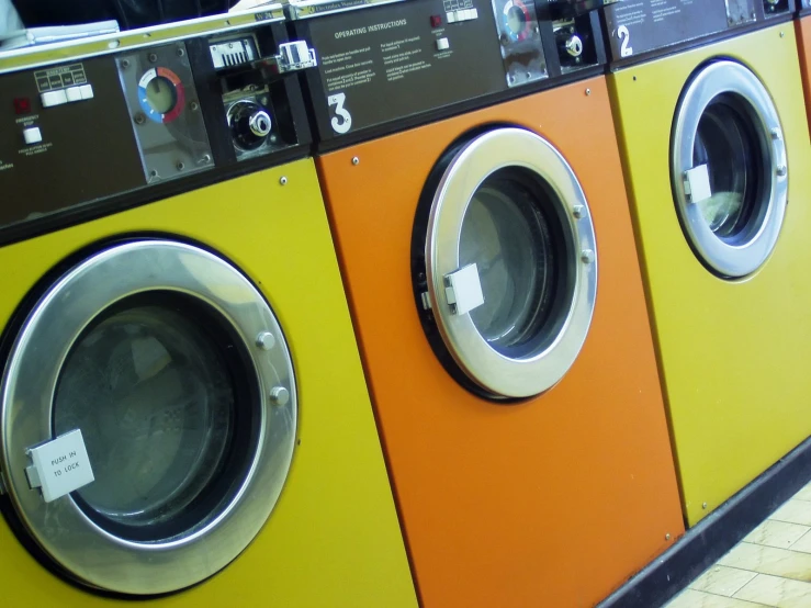 three washers are seen side by side at a laundries