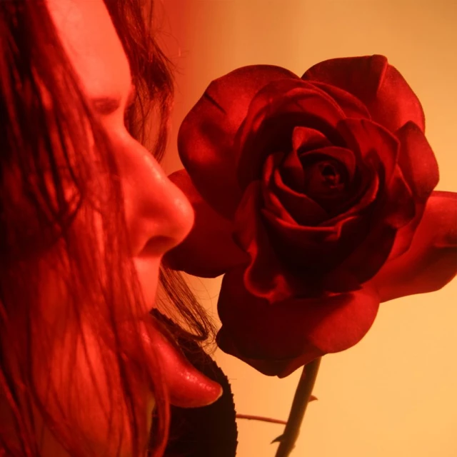 a red rose is sitting on the head of a woman