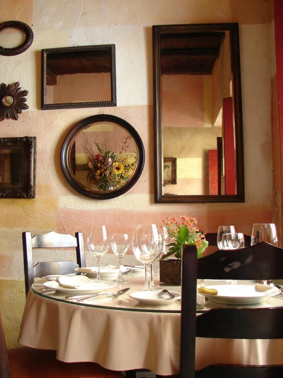 a table with wine glasses and plates is set for a meal