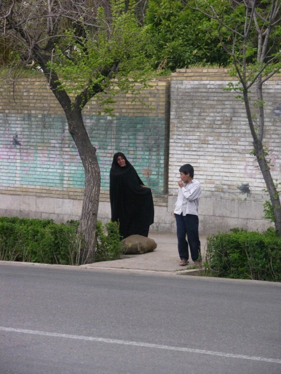 a woman standing next to a tree and a street