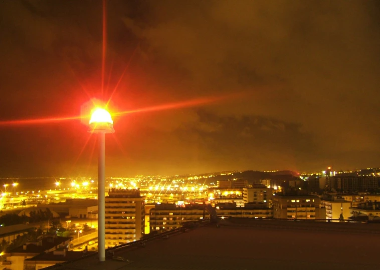 a red street light above the city at night