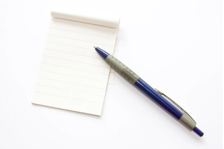 a blue pen and an empty notebook on white background