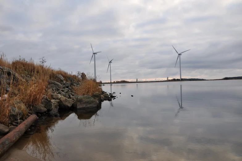 some wind turbines and the water in front of them