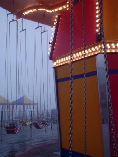 a carnival ride with swings in the rain