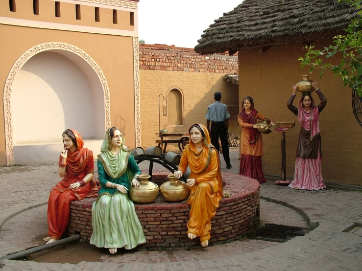 some statues of women are sitting on a table