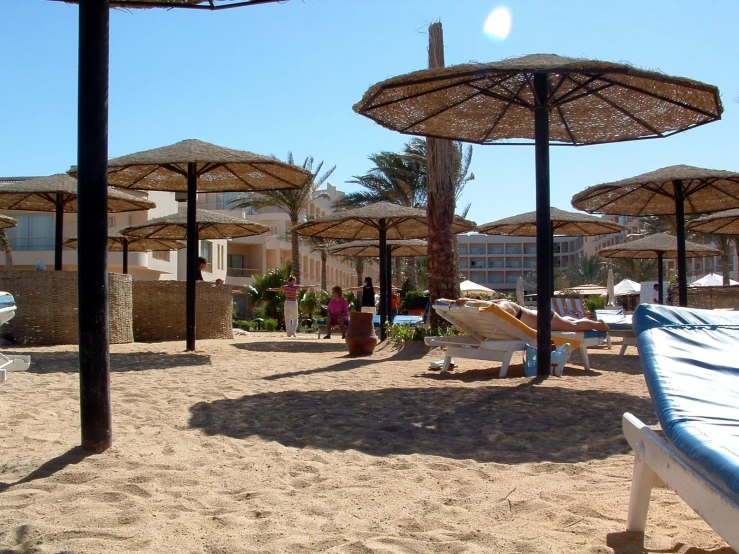 beach chairs sitting under umbrellas on sand and sea