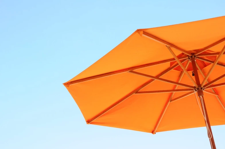 an orange umbrella is open on top of a table