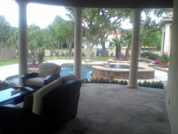 a nice outdoor living area with columns and an outside fireplace