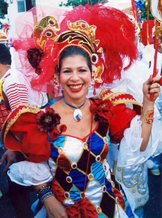 a woman wearing red and blue clothes with a big hat on top